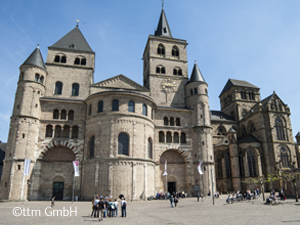 Mitten im Trierer Stadtzentrum gelegen, steht der Trierer Dom - die ältestes Bischofskirche Deutschlands - heute über einer ehemaligen konstantinischen Palastanlage, die im frühen 4. Jahrhundert durch die größte christliche Kirchenanlage der Antike überbaut wurde. Sie bestand aus vier Basiliken, die durch ein großes Taufbecken miteinander verbunden waren, und bedeckte eine Fläche, die an ihren Grenzen bis zum heutigen Hauptmarkt reichte.