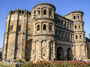Für den gerade in Trier eingetroffenen Gast ist die Porta Nigra der vorteilhafteste Ausgangspunkt für eine Stadterkundung. Die Porta Nigra ist das am besten erhaltene römische Stadttor nördlich der Alpen - eine unvergleichliche Verbindung zwischen der antiken Vergangenheit und der heutigen modernen Stadt.Die Porta Nigra selbst stammt aus einer Zeit (ca. 180 n. Chr.), als die Römer öffentliche Gebäude gerne aus großen Quadern (die größten wiegen hier sechs Tonnen) errichteten.